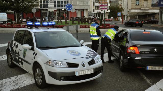 Dos agentes paran a un vehículo en un control realizado en O Carballiño, Orense.