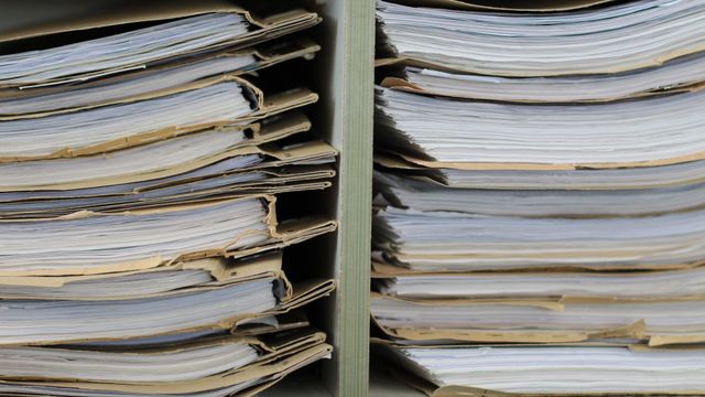 Expedientes acumulados en una estantería.