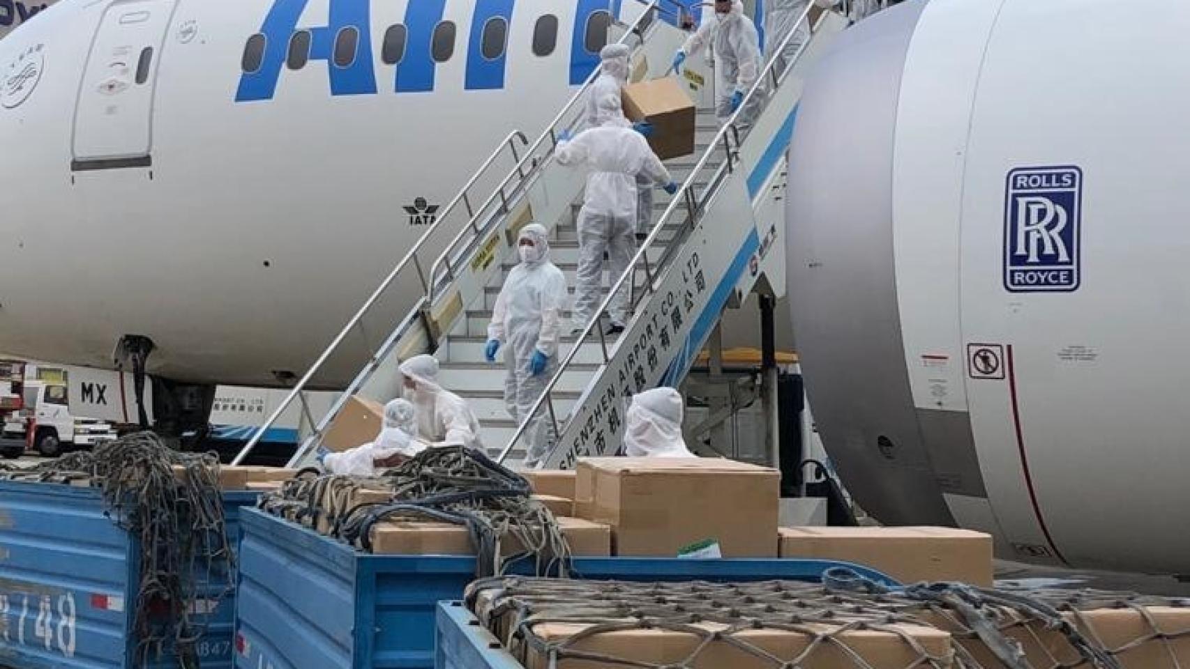 Operarios descargan material sanitario de un avión.