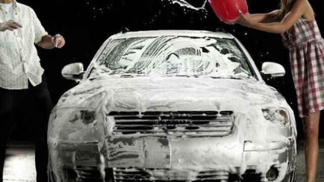 Una pareja limpiando su vehículo.