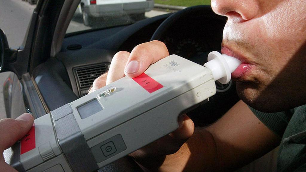 Un conductor soplando durante un control de alcoholemia.