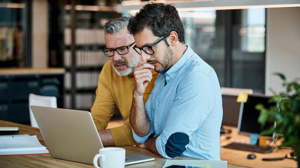 Dos hombres trabajando frente a un ordenador.