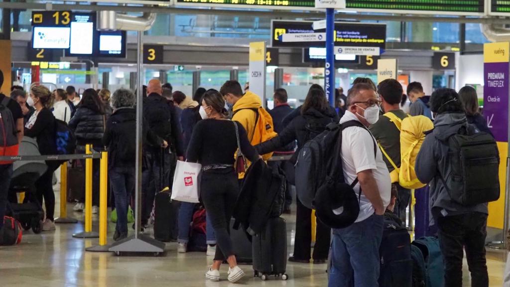 Pasajeros en un aeropuerto esperando información sobre su avión.