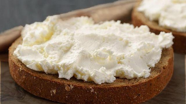 Una rebanada de pan con queso para untar.