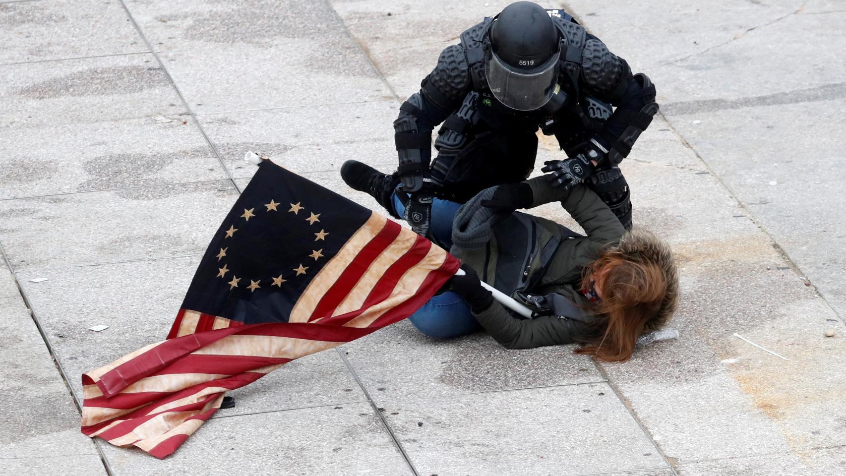 Un policía detiene a uno de los manifestantes proTrump en las puertas del Capitolio.
