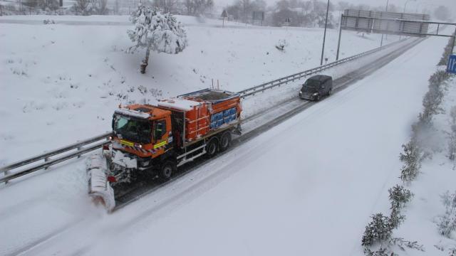 Una máquina quitanieves despeja el camino en la autopista M-40, en Madrid este sábado.