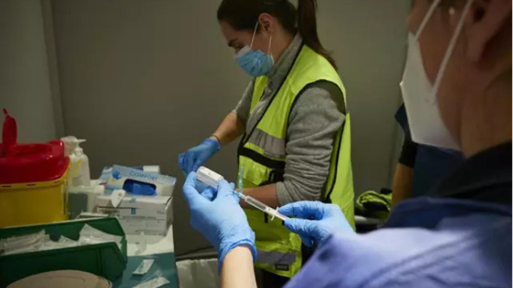 Dos sanitarios preparando la vacuna contra la Covid-19.