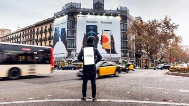 Un joven con uno de los soportes digitales móviles de Mundooh.