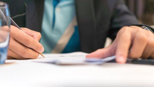 Imagen de archivo de una persona firmando un documento.