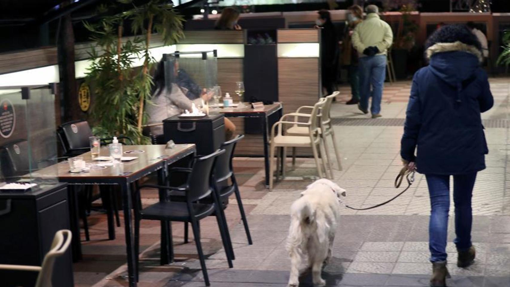 Un hombre pasea delante de una terraza.