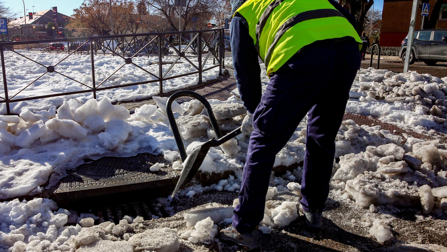 Un operario limpia nieve del alcantarillado de Madrid antes de que comiencen las lluvias en la capital.