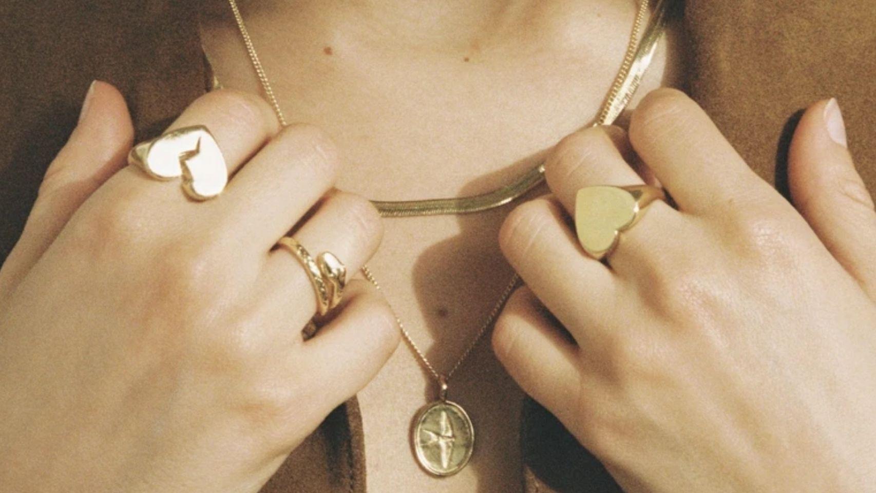 Una mujer exhibe varias joyas de oro.