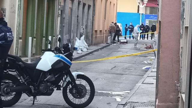 Los equipos de investigación franceses analizan el cartón ensangrentado en la calle.