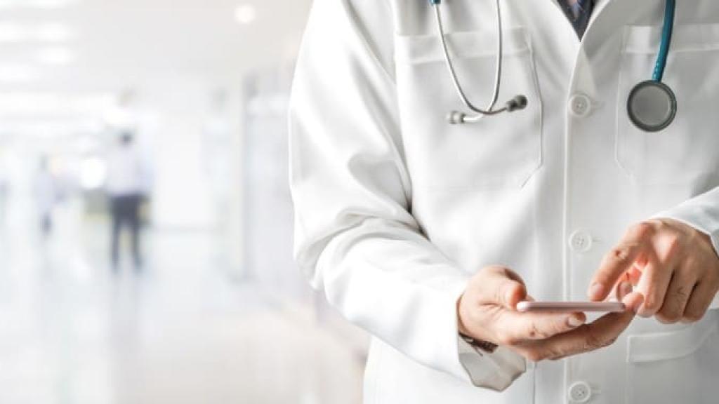 Un médico consultando su móvil.