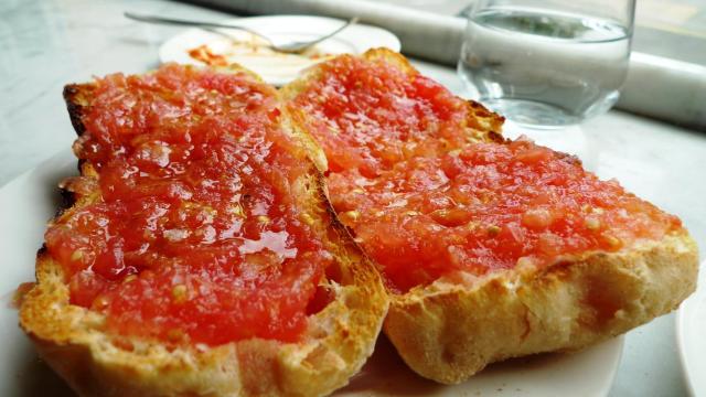 Una imagen de pan con tomate.