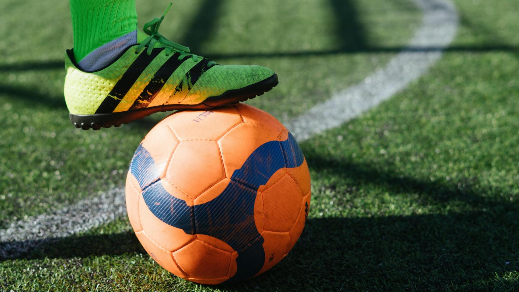 Futbolista sujeta con el pie el balón