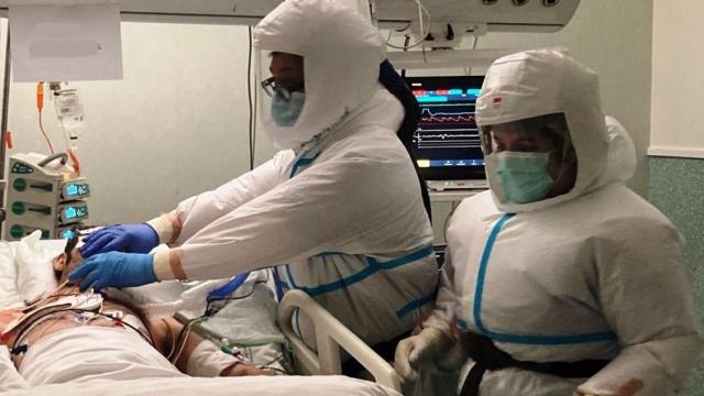 Dos profesionales sanitarios atendiendo a un paciente.