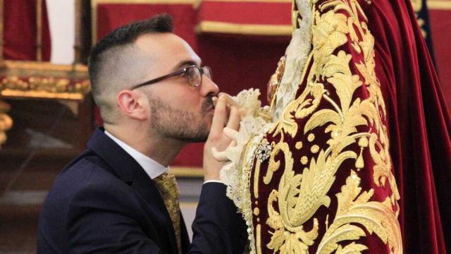 Álvaro Abril, besando la mano de una de las imágenes que arregla.