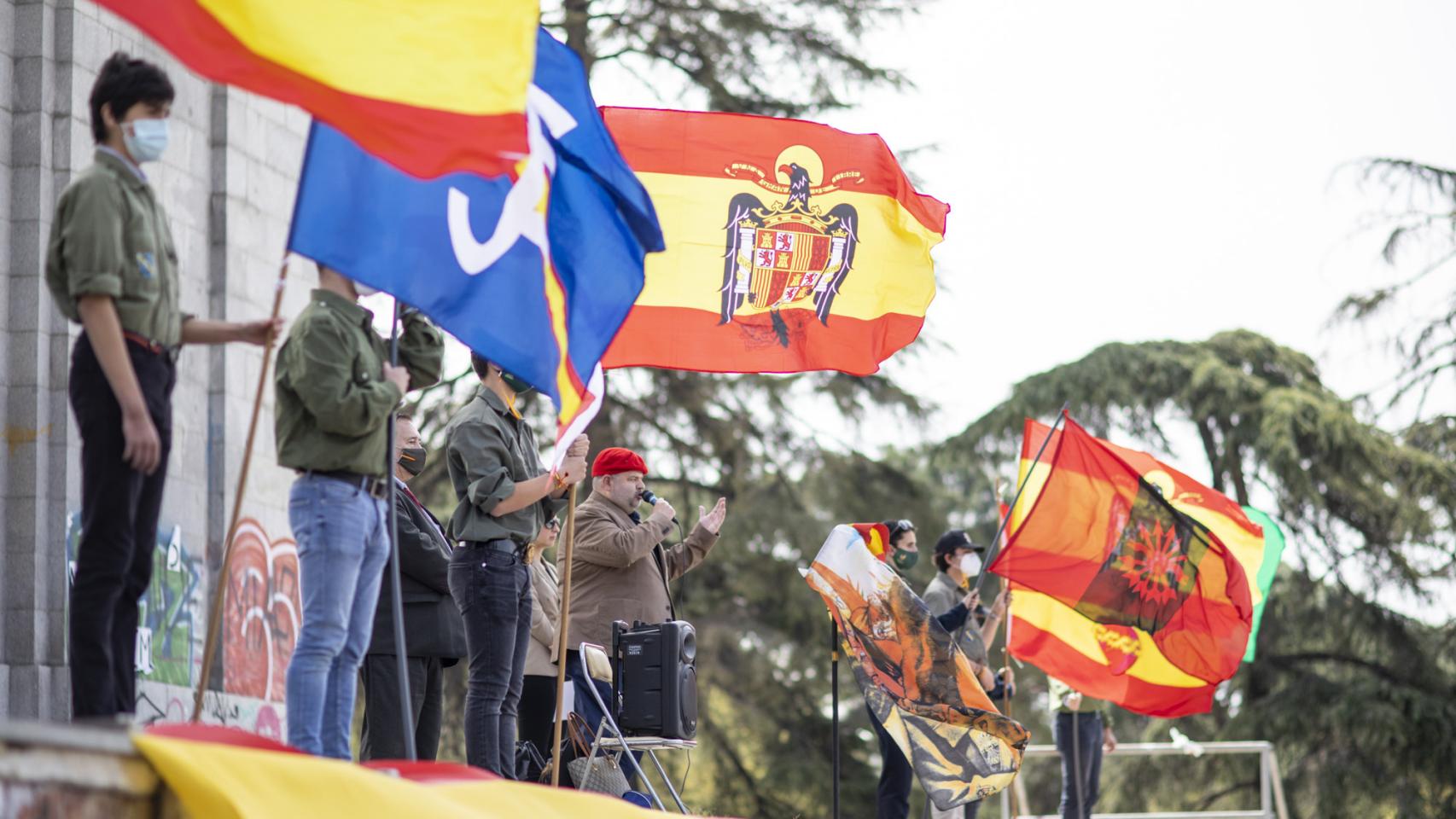 Varios adolescentes miembros de Acción Juvenil Española se manifiestan en el Arco de la Victoria este domingo.