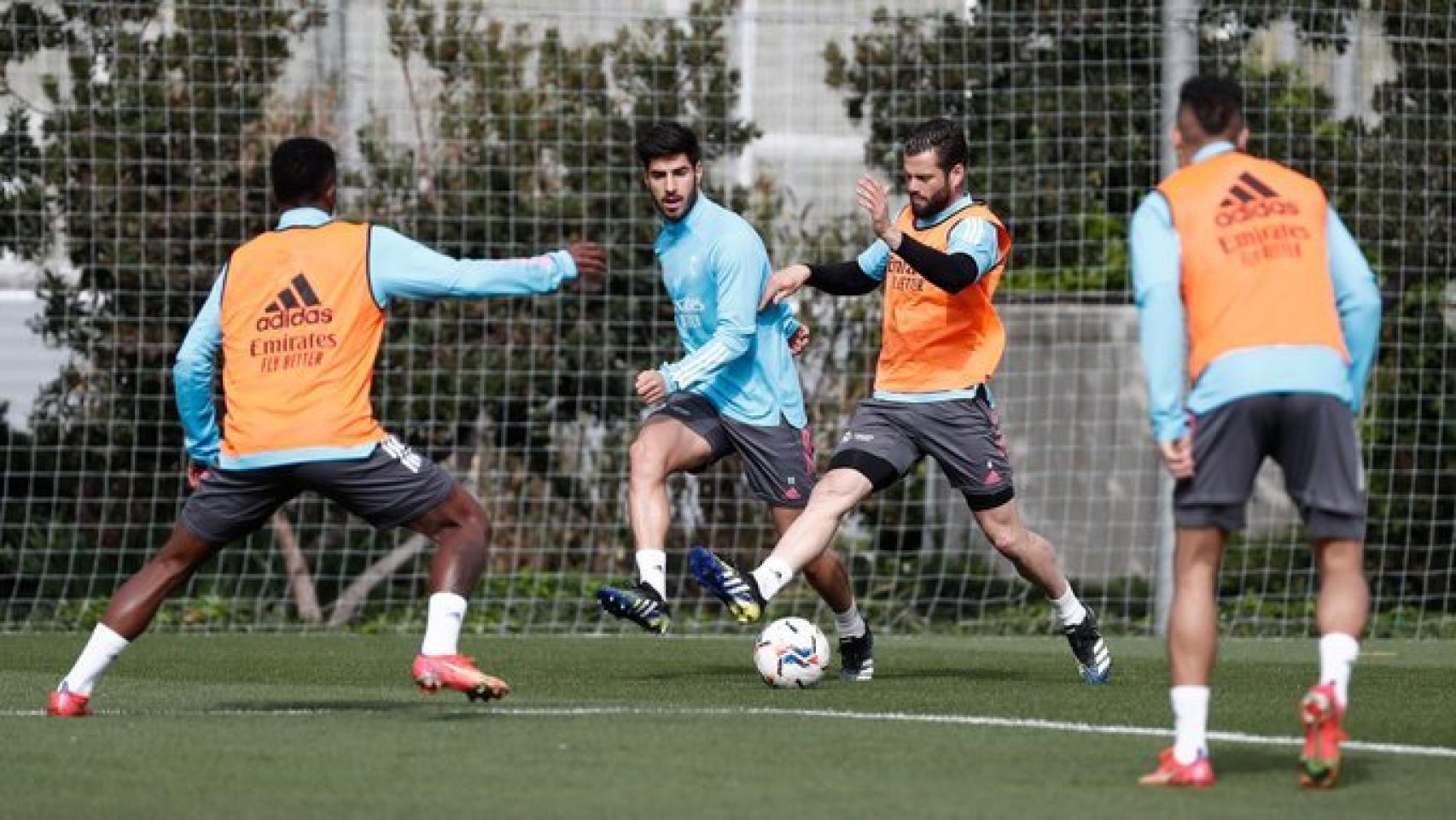 Nacho Fernández controla un balón ante la presión de Marco Asensio