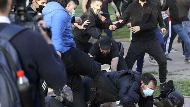 Un radical de izquierdas patea a un antidisturbios durante el acto de Vox en Vallecas.
