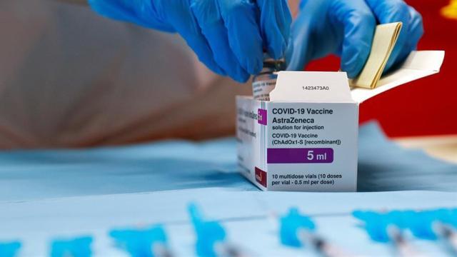 Un sanitario abriendo una caja de vacunas de AstraZeneca.