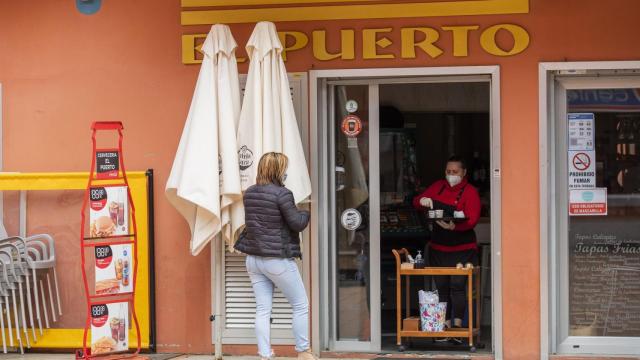 Una hostelera atiende a una clienta desde el exterior del local, en O Grove.