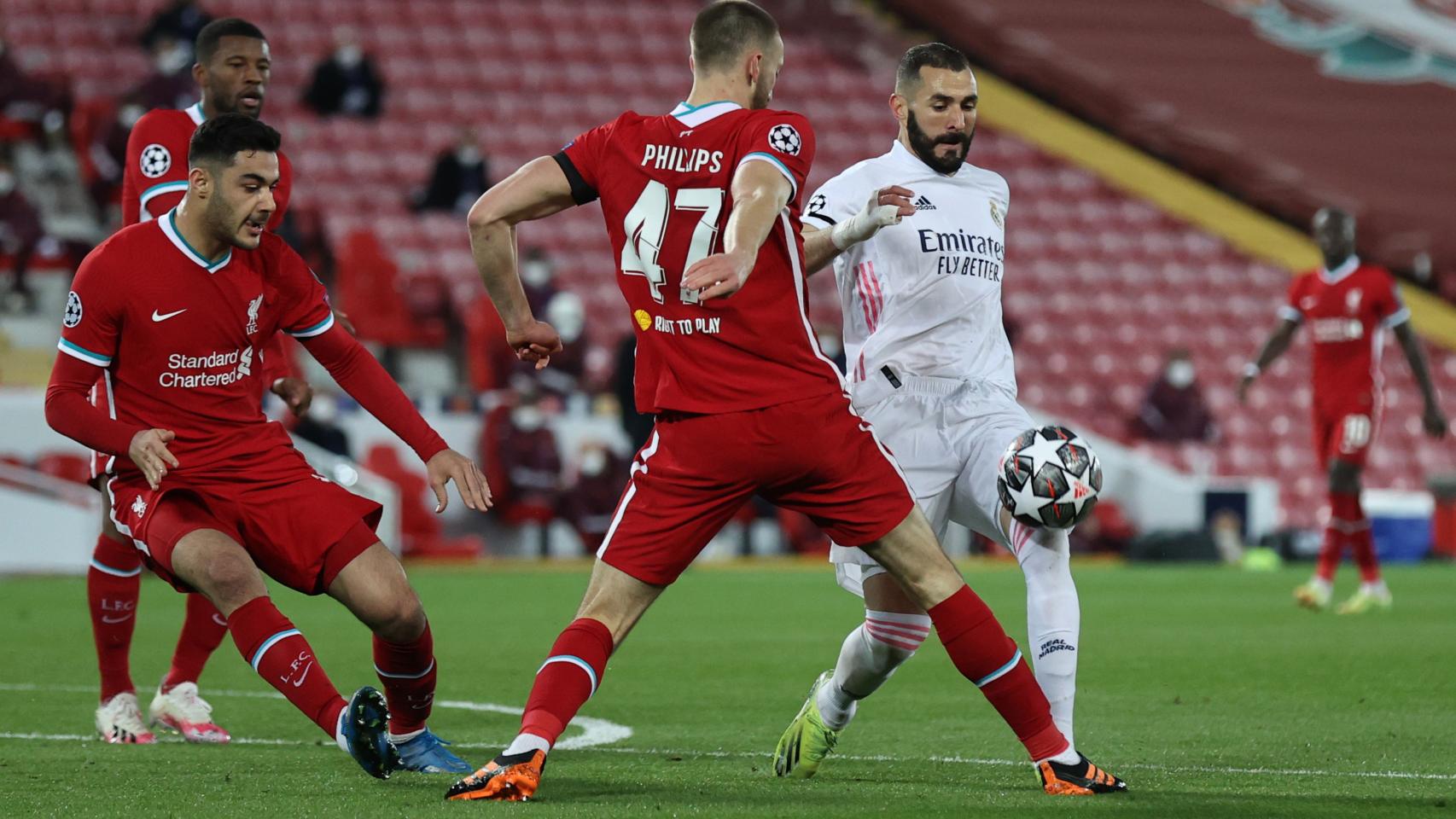Karim Benzema intenta entrar en el área del Liverpool y es presionado por Nathaniel Phillips