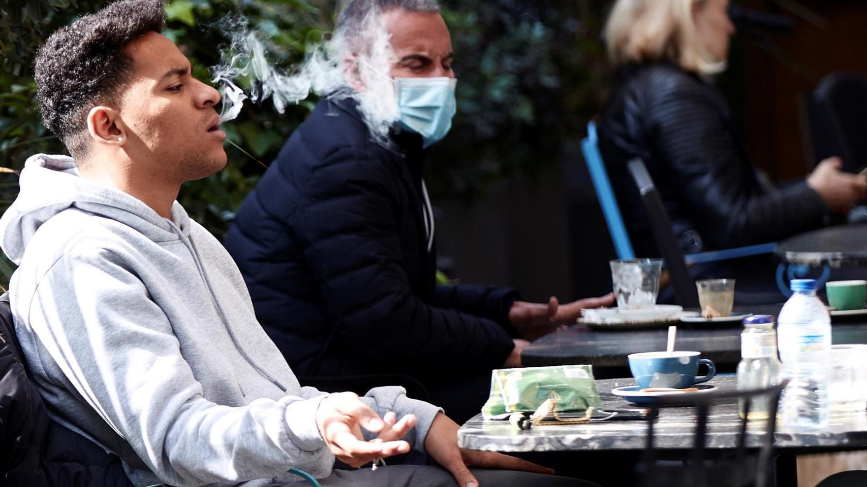 Un joven fumando en un bar de Barcelona.