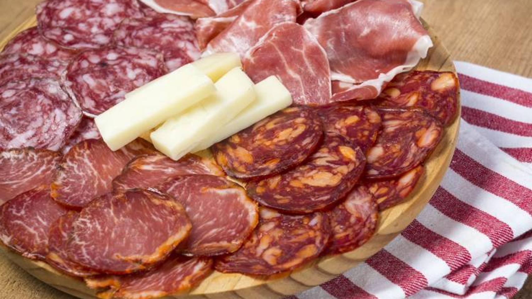 Un plato con distintos embutidos y queso.