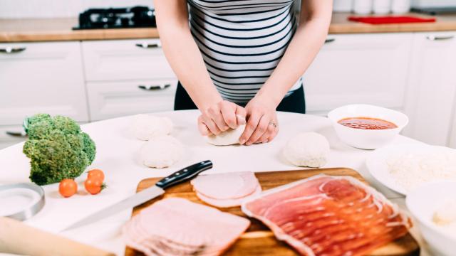 Una mujer embarazada comiendo jamón y otros embutidos.