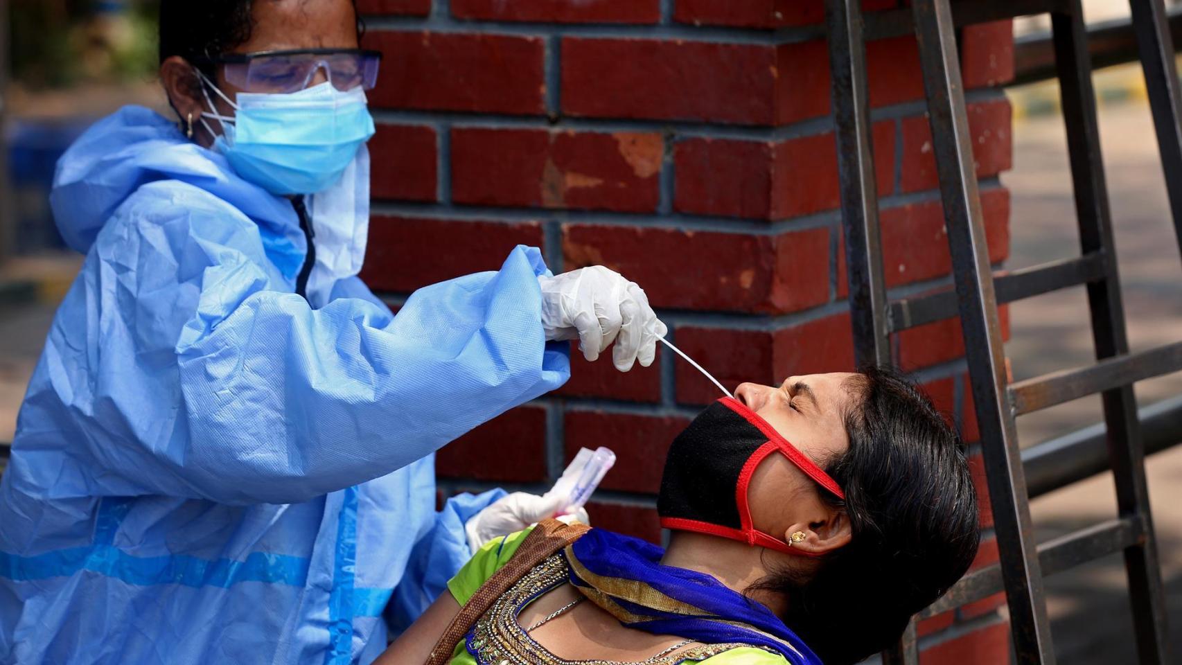 Una sanitaria india realizando una PCR.