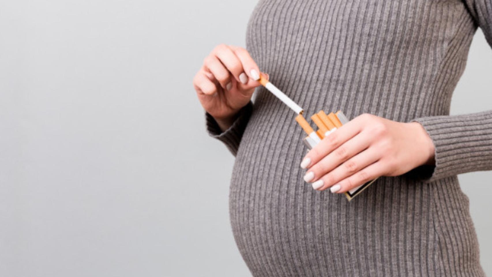 Una mujer embarazada con varios cigarrillos.