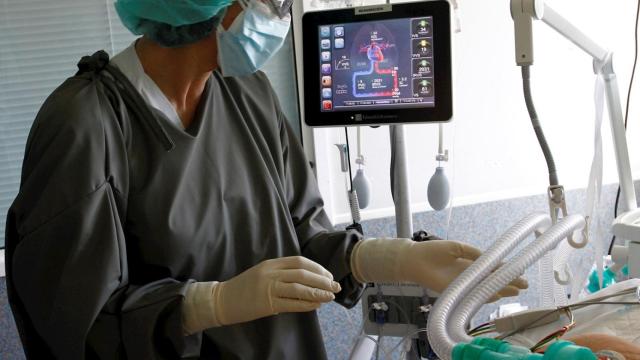 Una sanitaria atiende a un paciente con COVID-19 en el Complejo Hospitalario Universario de Ferrol. EFE/Kiko Delgado