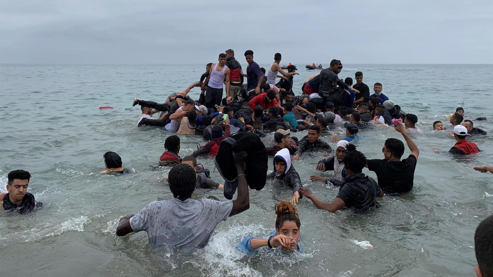 Varias personas se hacen con una embarcación de las autoridades marroquíes para cruzar los espigones de Ceuta.