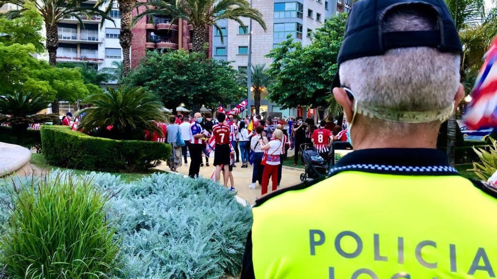 Agente vigilando la celebración del campeonato de Liga por parte de aficionados del Atlético de Madrid.