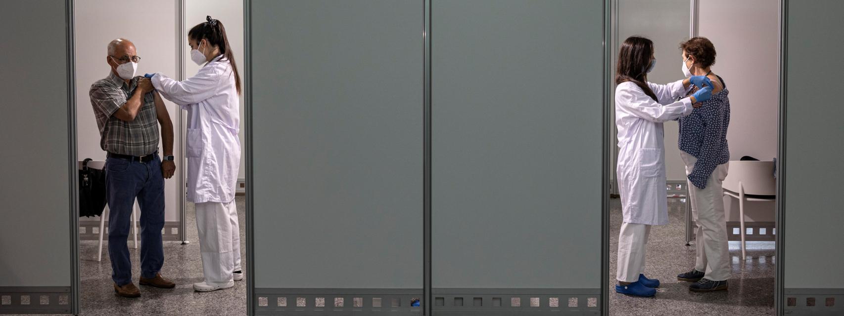 Dos personas de entre 66 y 69 años reciben la segunda dosis de la vacuna contra la covid-19 de Pfizer.