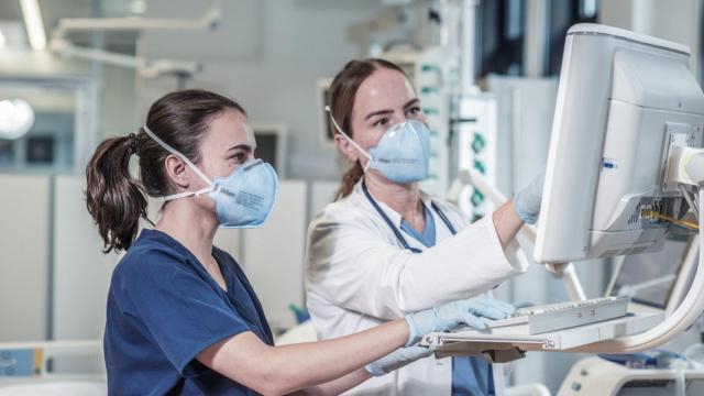 Dos sanitarias manipulando un equipo médico.