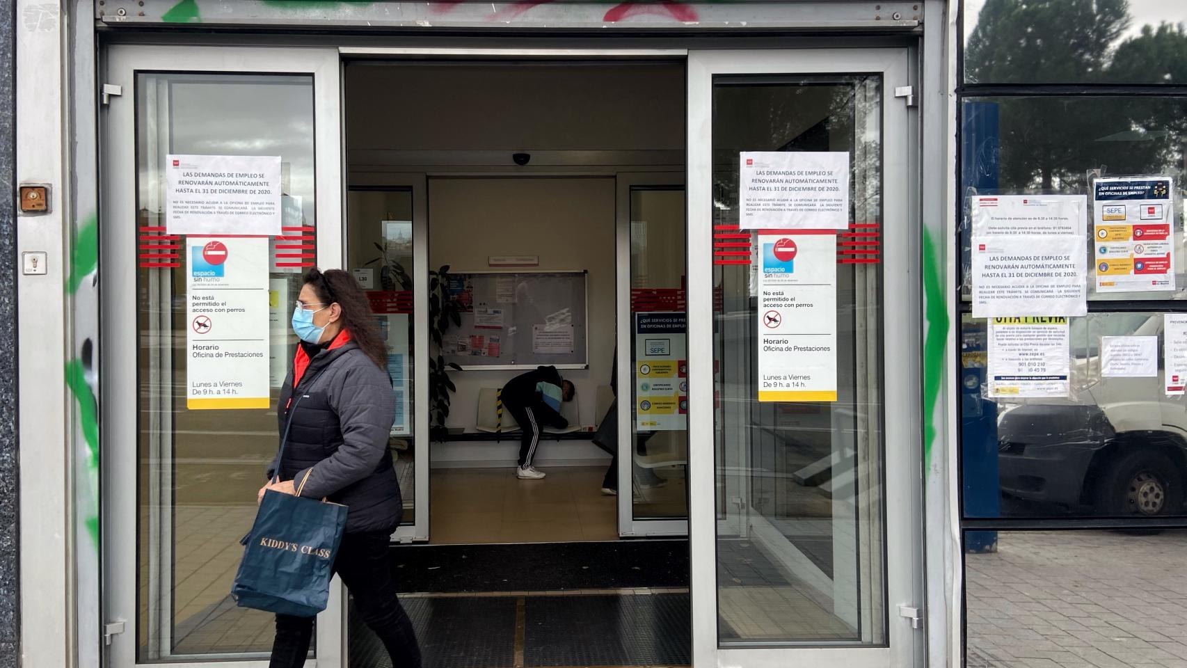 Una mujer, delante de una oficina de empleo.