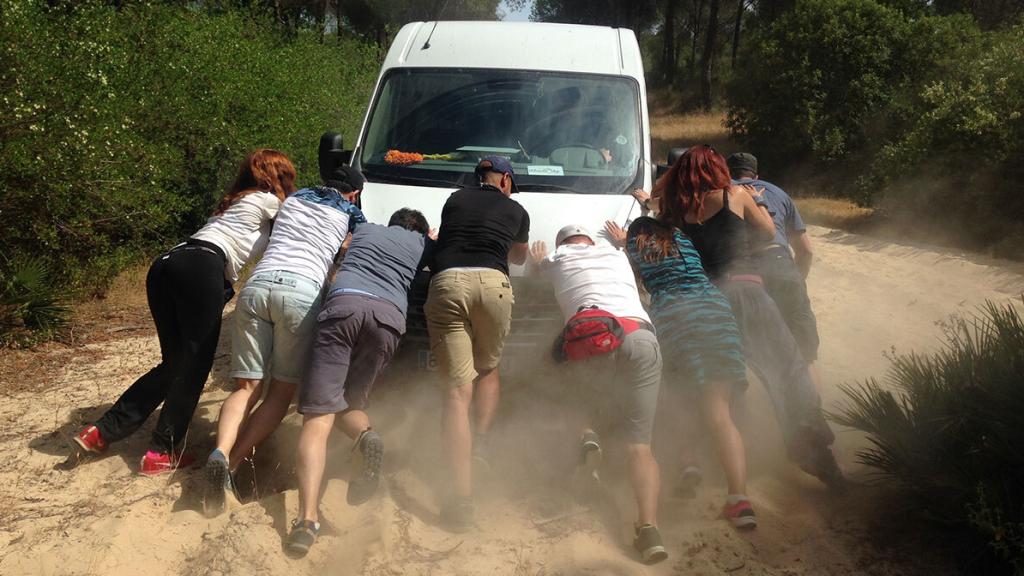 Parte del equipo empujando una furgoneta, en una grabación.