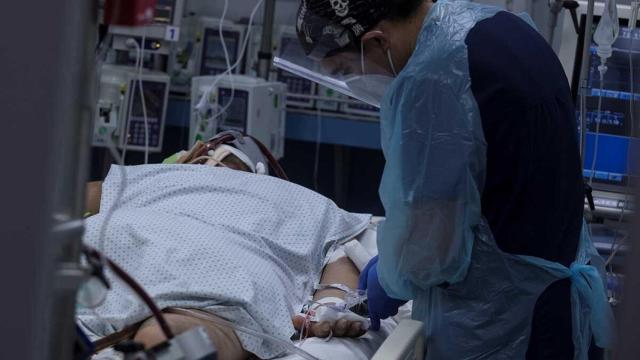 Un sanitario atiende a una persona con coronavirus.