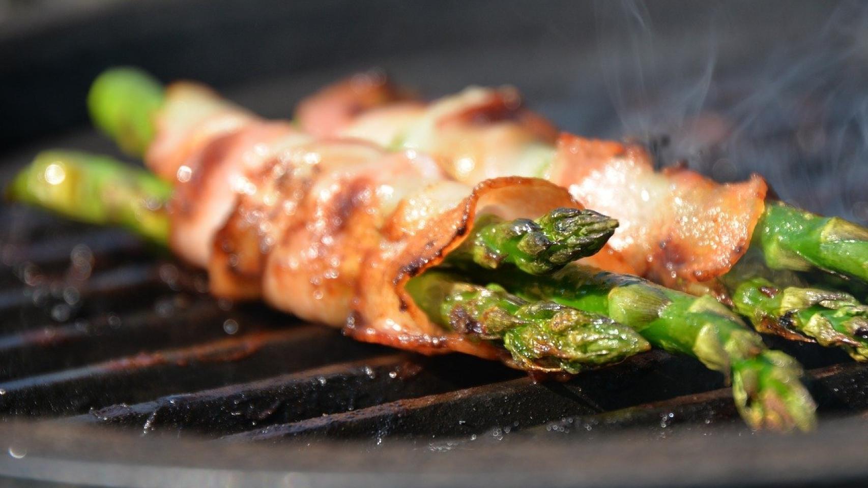 Unos espárragos haciéndose en una barbacoa.