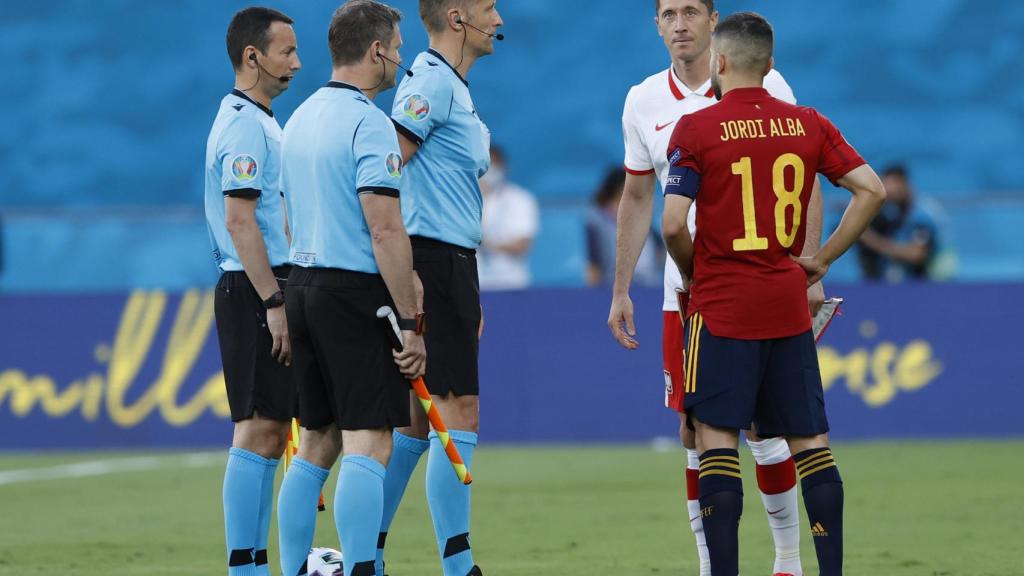 Robert Lewandowski y Jordi Alba dialogan con el colegiado Daniele Orsato