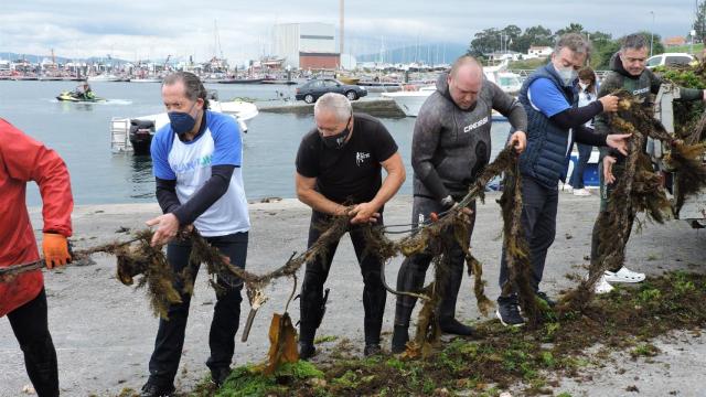 Voluntarios, entre ellos Francisco Botas y Juan Carlos Escotet, descargan los residuos en el puerto