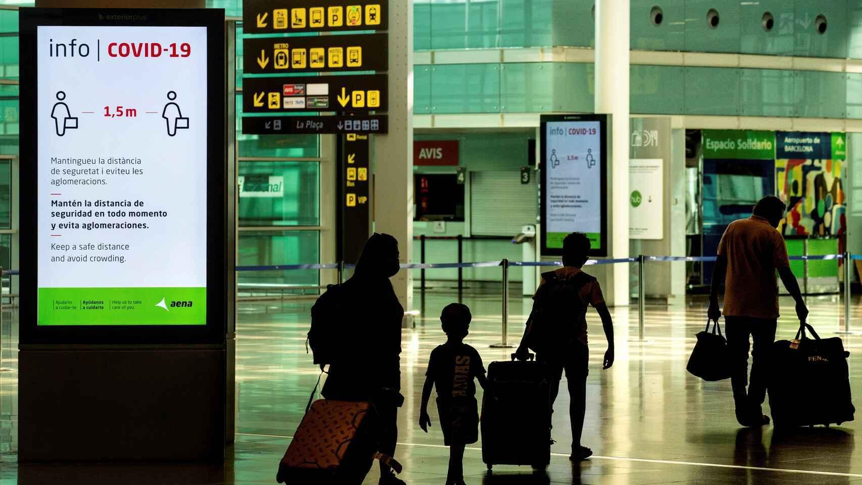 Viajeros con mascarillas en un aeropuerto.