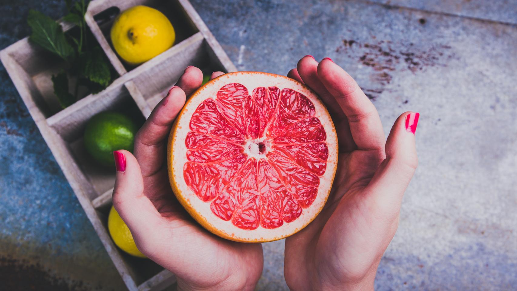 Una mujer sujeta un pomelo.