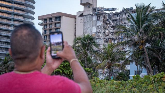 Un hombre fotografía los destrozos del edificio de 12 pisos derrumbado en Miami.