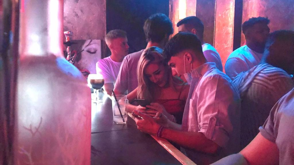 Clientes consumen sus copas en la barra de un local de ocio nocturno