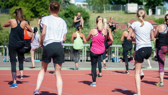 Un grupo de personas hacen zumba.