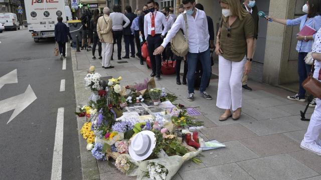 Varias personas observan el altar colocado en la acera donde fue golpeado Samuel.